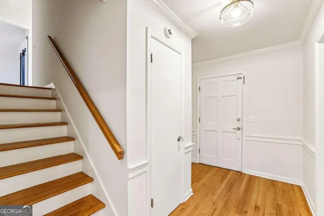 a view of a hallway with wooden floor and staircase