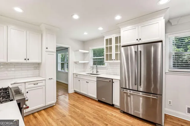 a kitchen with stainless steel appliances a refrigerator sink and cabinets