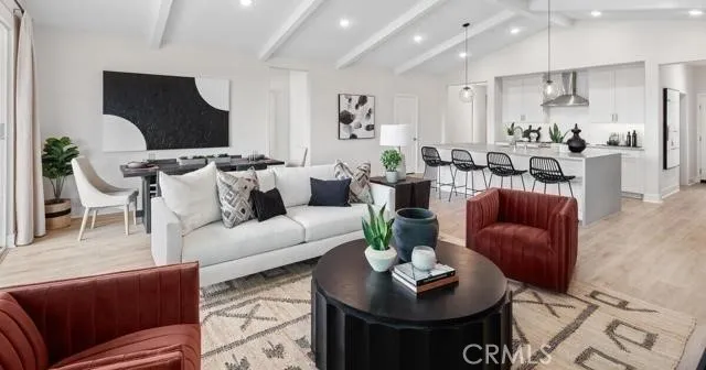 a living room with furniture potted plant and kitchen view