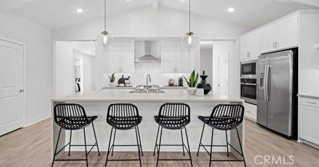 42409 Lamporo Way Indio, CA 92203 - Photo 7 of 24 a kitchen with stainless steel appliances a table chairs refrigerator and wooden floor