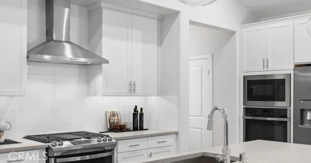 a kitchen with stainless steel appliances granite countertop white cabinets and a stove