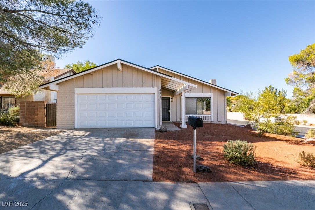 Single story home with driveway, board and batten siding, brick siding, and an attached garage