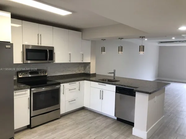 a kitchen with stainless steel appliances a stove microwave and sink
