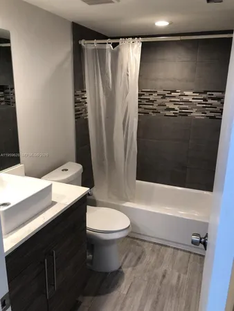 a bathroom with a sink a toilet a mirror and shower
