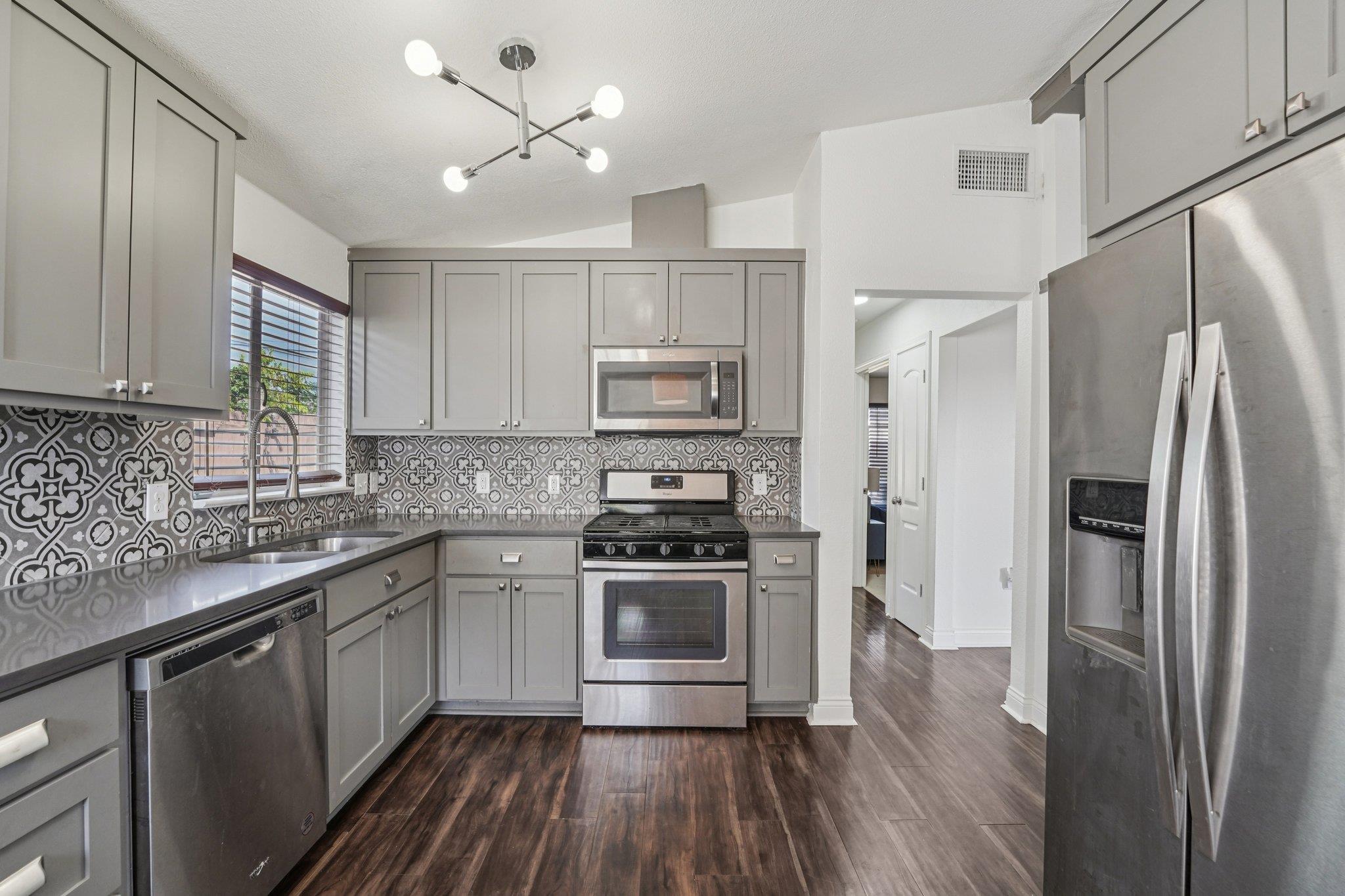 3705 Manorwood Road Austin, TX 78723 - Photo 5 of 13 a kitchen with stainless steel appliances a stove a sink and a refrigerator