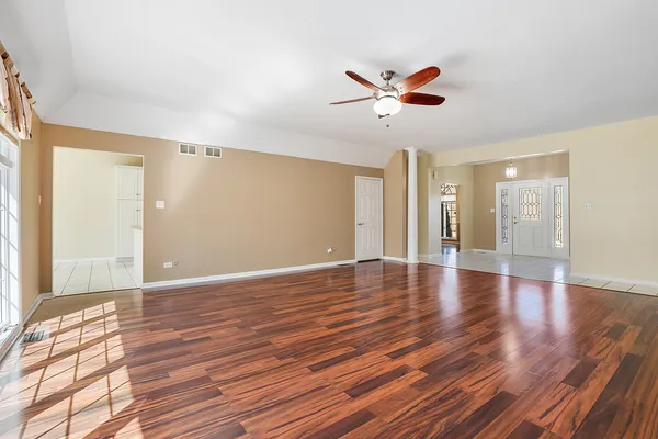 a view of a livingroom with wooden floor and a ceiling fan