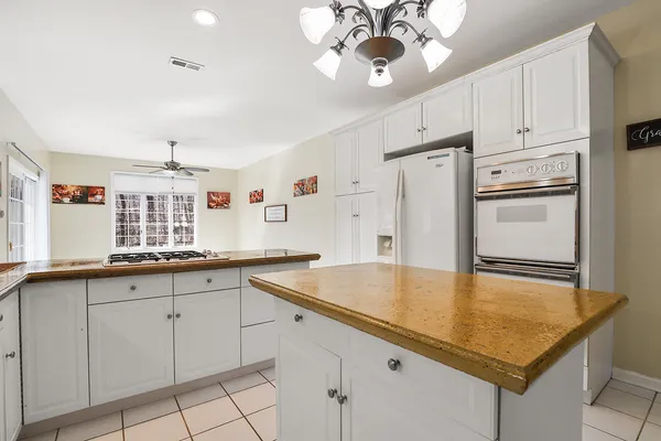 a kitchen with kitchen island granite countertop a sink a center island and cabinets