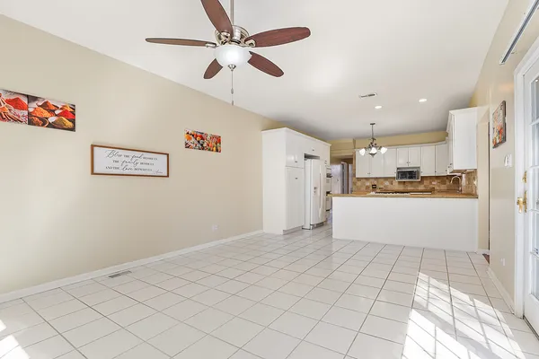 a view of kitchen with stainless steel appliances cabinets and a ceiling fan