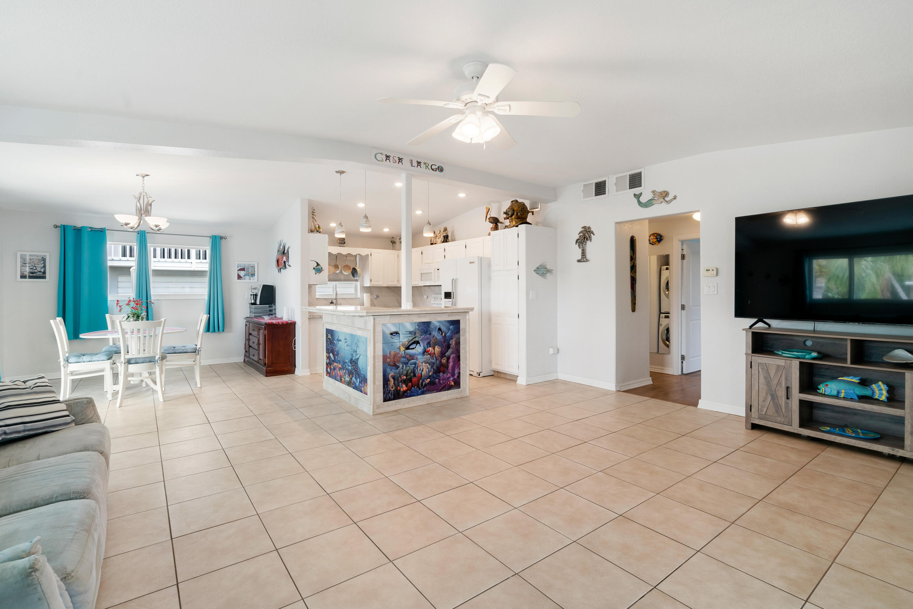 1210 Cactus Street Key Largo, FL 33037 - Photo 8 of 41 a large white kitchen with furniture and a flat screen tv