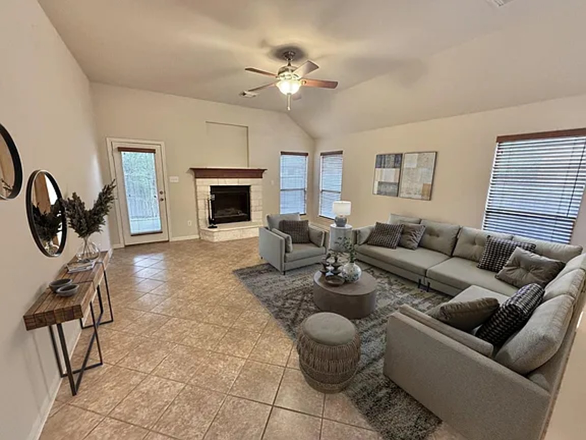 608 Pebblestone Walk Drive Cedar Park, TX 78613 - Photo 12 of 27 Living room featuring ceiling fan, a fireplace with raised hearth, light tile patterned floors, and lofted ceiling