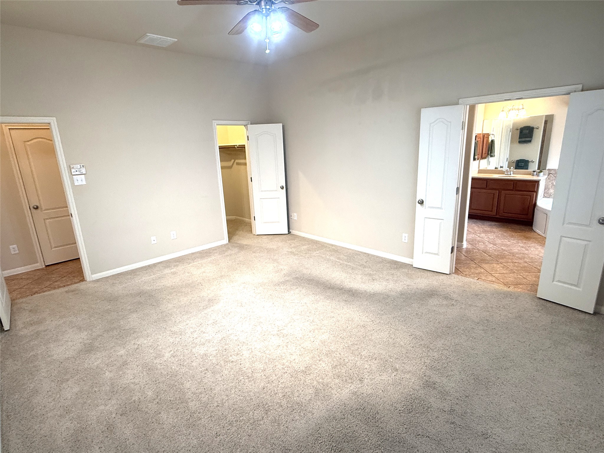 608 Pebblestone Walk Drive Cedar Park, TX 78613 - Photo 14 of 27 Unfurnished bedroom with light carpet, a spacious closet, and a ceiling fan