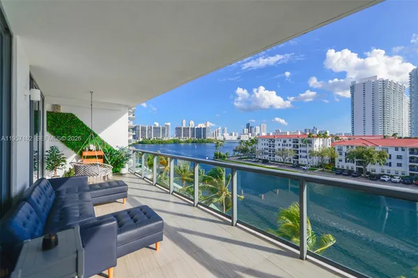 a view of a balcony with dining table and chairs
