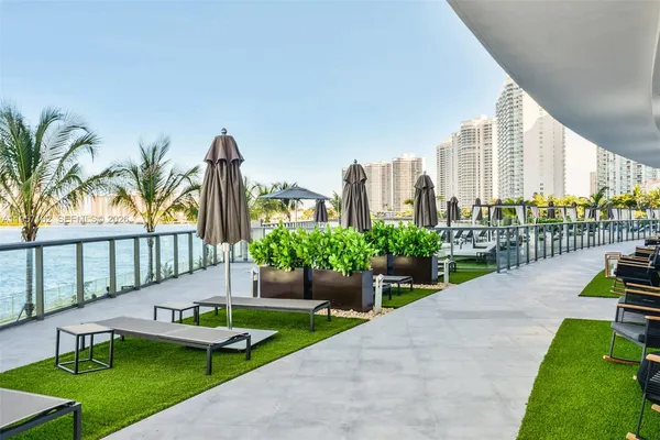 a view of a terrace with glass top table and chairs