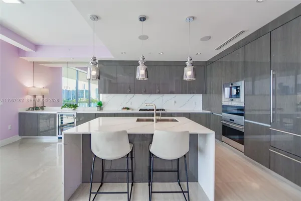 a kitchen with a table chairs refrigerator and cabinets