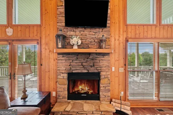 a living room with furniture a fireplace and a floor to ceiling window