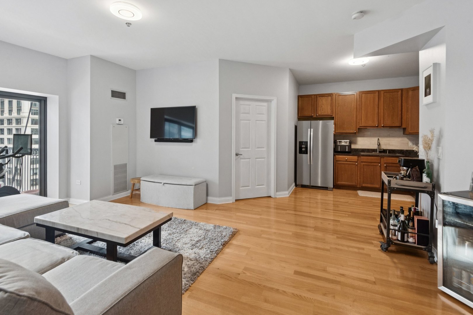 8 West Monroe Street, Unit 1209 Chicago, IL 60603 - Photo 9 of 24 a living room with stainless steel appliances kitchen island granite countertop a stove a sink dishwasher and a microwave oven with wooden floor