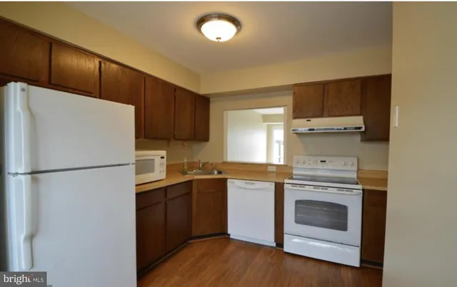 a kitchen with a white stove top oven and refrigerator