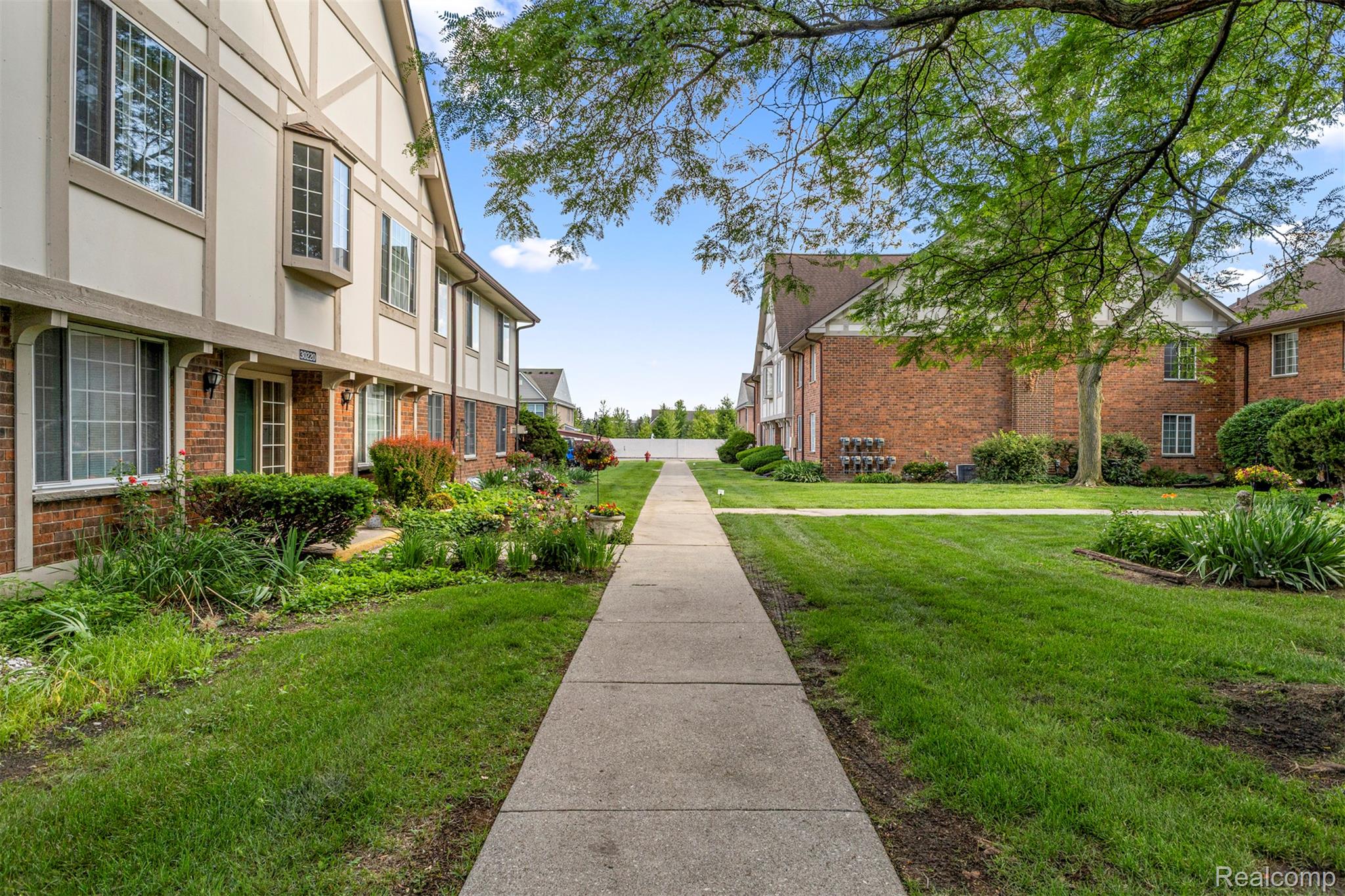 30220 Southfield Road Southfield, MI 48076 - Photo 6 of 13 Concrete walkway bordered by green lawns and mature landscaping