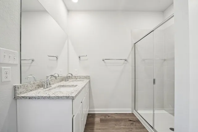 a bathroom with a granite countertop sink a toilet and shower