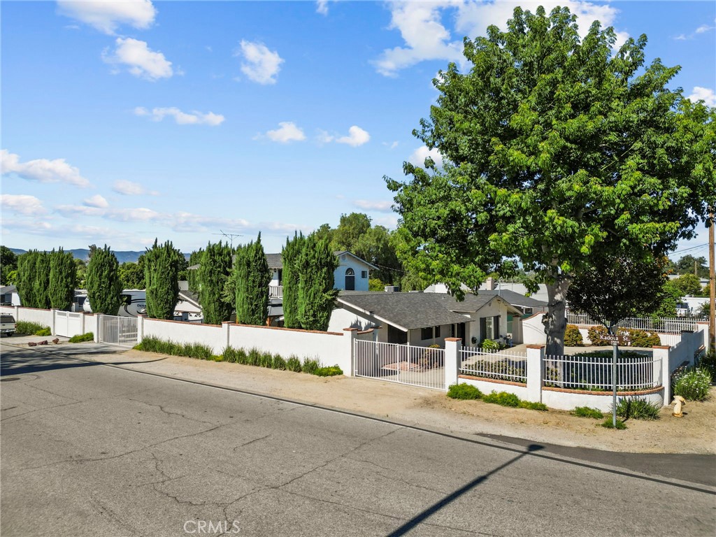 4790 Adam Road Simi Valley, CA 93063 - Photo 5 of 61 a view of a white house with a big yard and large tree