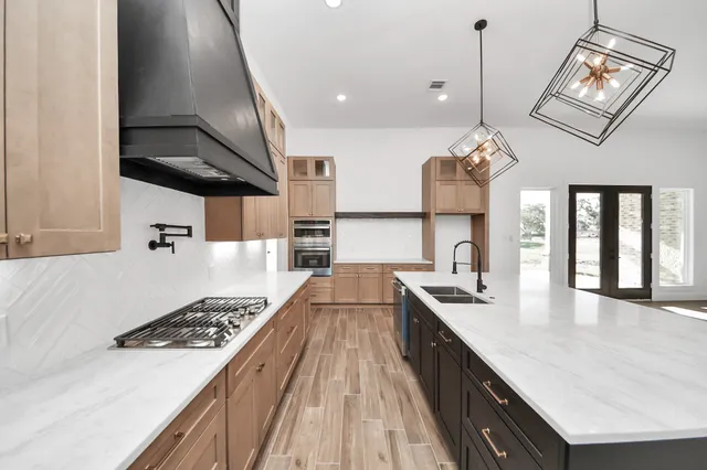 a large kitchen with a sink and a stove top oven