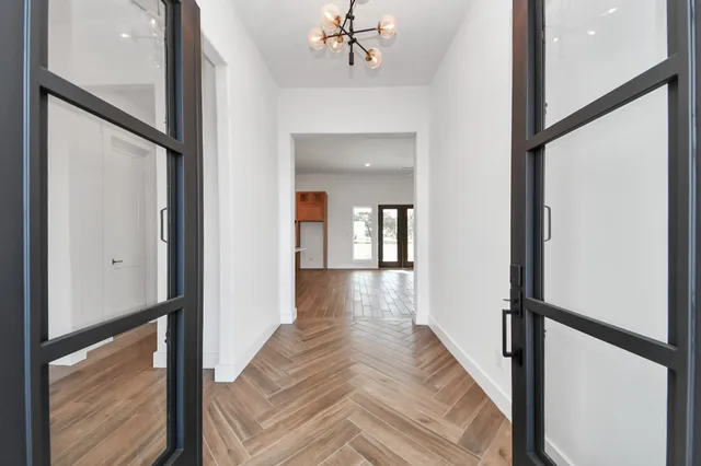 a view of a hallway with wooden floor and staircase