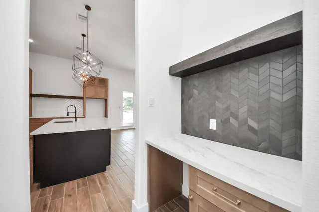 a kitchen with granite countertop a sink cabinets and stainless steel appliances