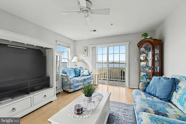 a living room with furniture chandelier and large windows