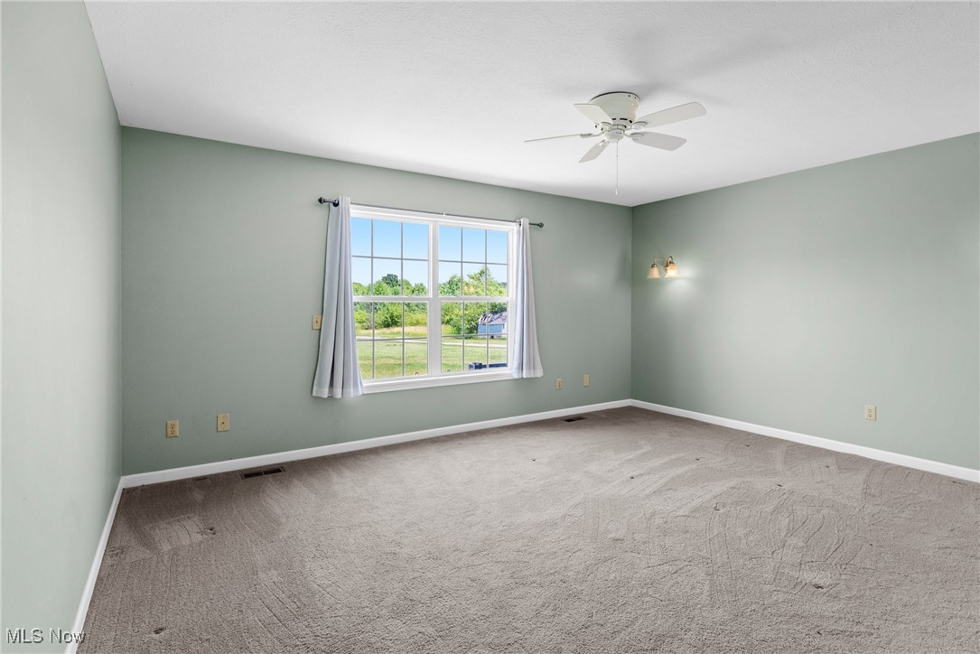 5215 River Road Madison, OH 44057 - Photo 17 of 36 Carpeted empty room featuring ceiling fan and baseboards