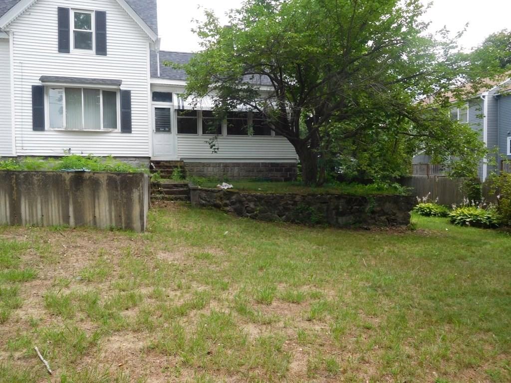 19 Juniper Street Lowell, MA 01852 - Photo 7 of 24 a front view of a house with a yard