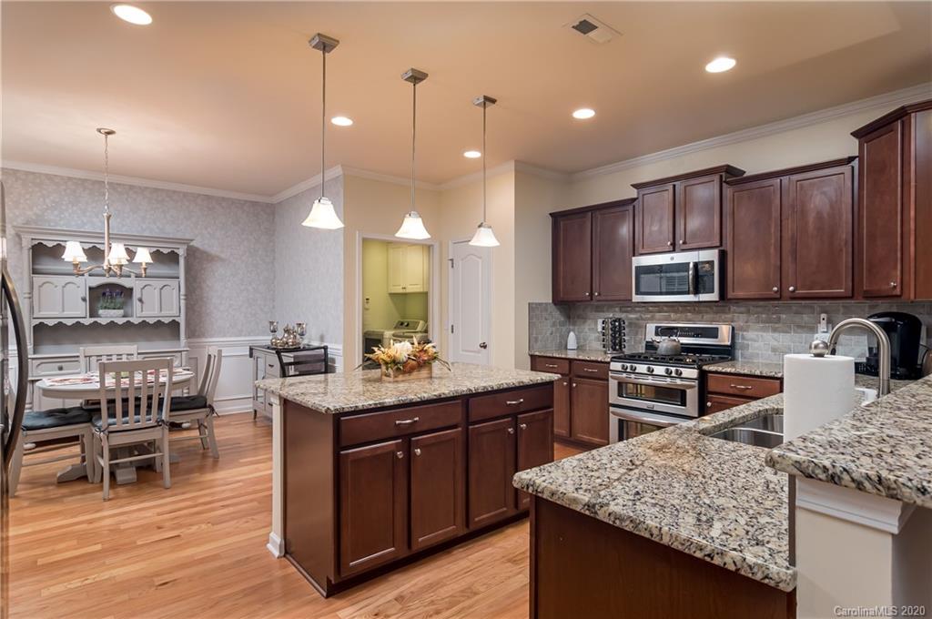 4344 Perth Road, Unit 240 Indian Land, SC 29707 - Photo 8 of 30 a kitchen with stainless steel appliances granite countertop wooden cabinets a stove a sink and a wooden floors