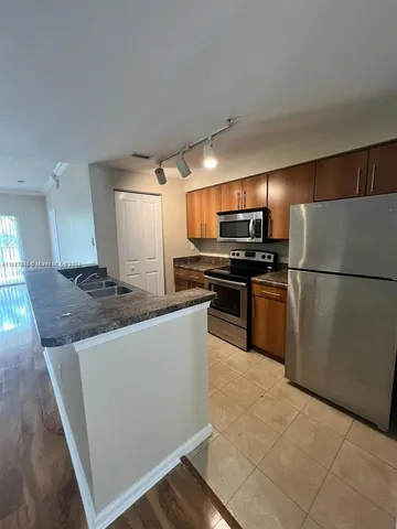 a view of an empty room with wooden floor and closet