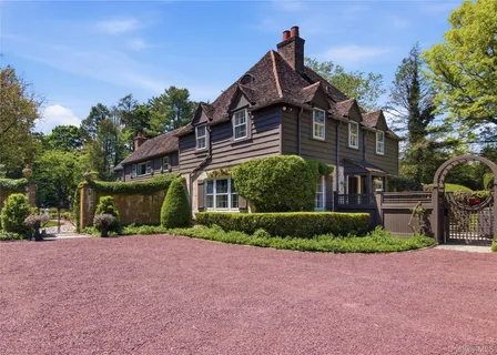 a front view of a house with a yard and potted plants