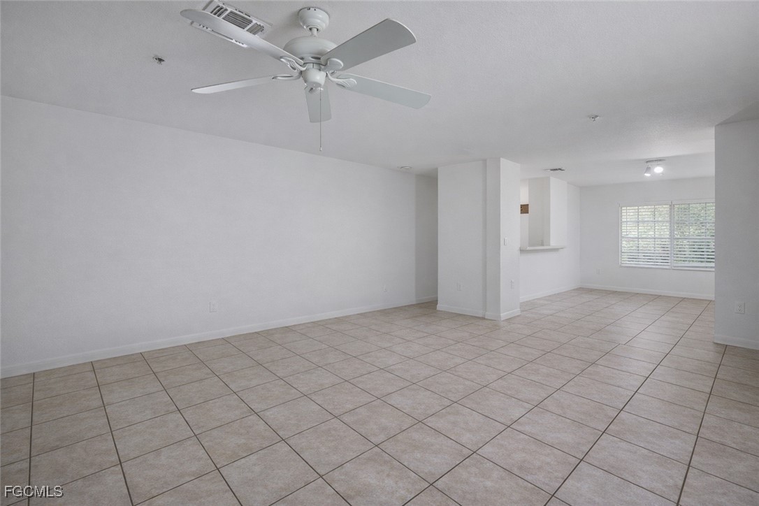 9460 Ivy Brook Run, Unit 710 Fort Myers, FL 33913 - Photo 7 of 23 an empty room with windows and ceiling fan