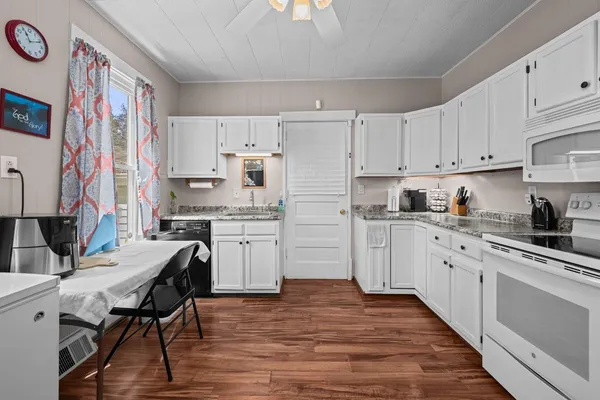 a kitchen with cabinets wooden floor and stainless steel appliances