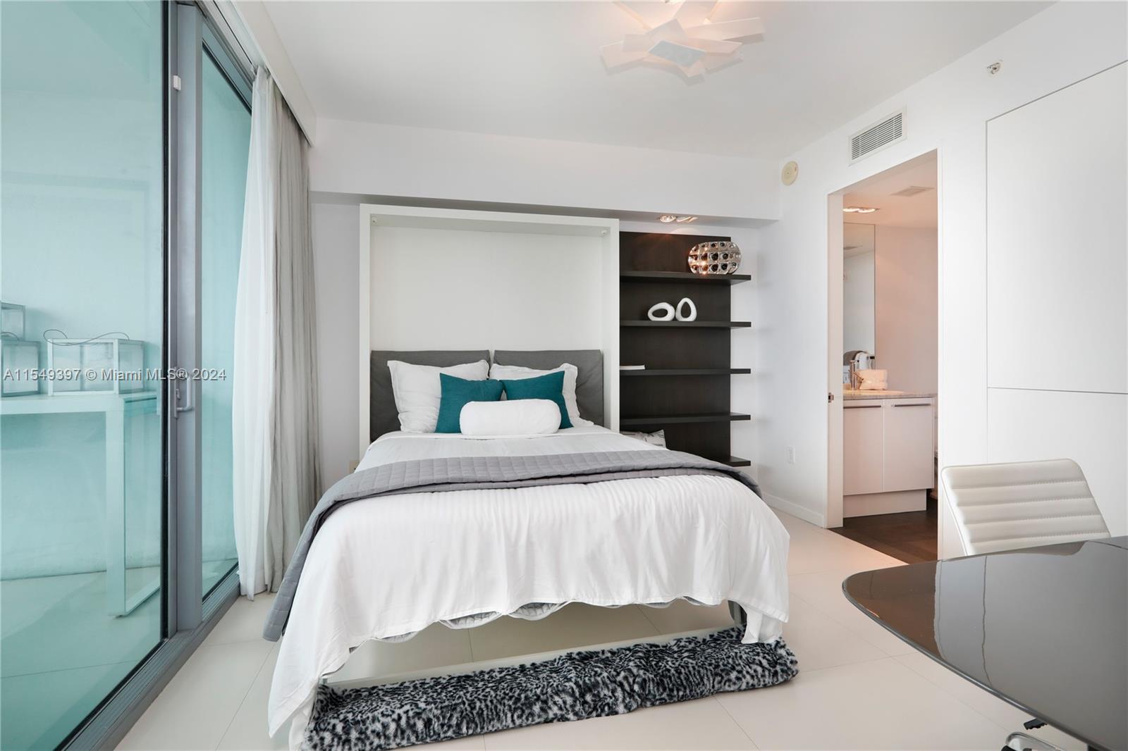 900 Biscayne Boulevard, Unit 705 Miami, FL 33132 - Photo 12 of 30 a bedroom with a bed and wooden floor