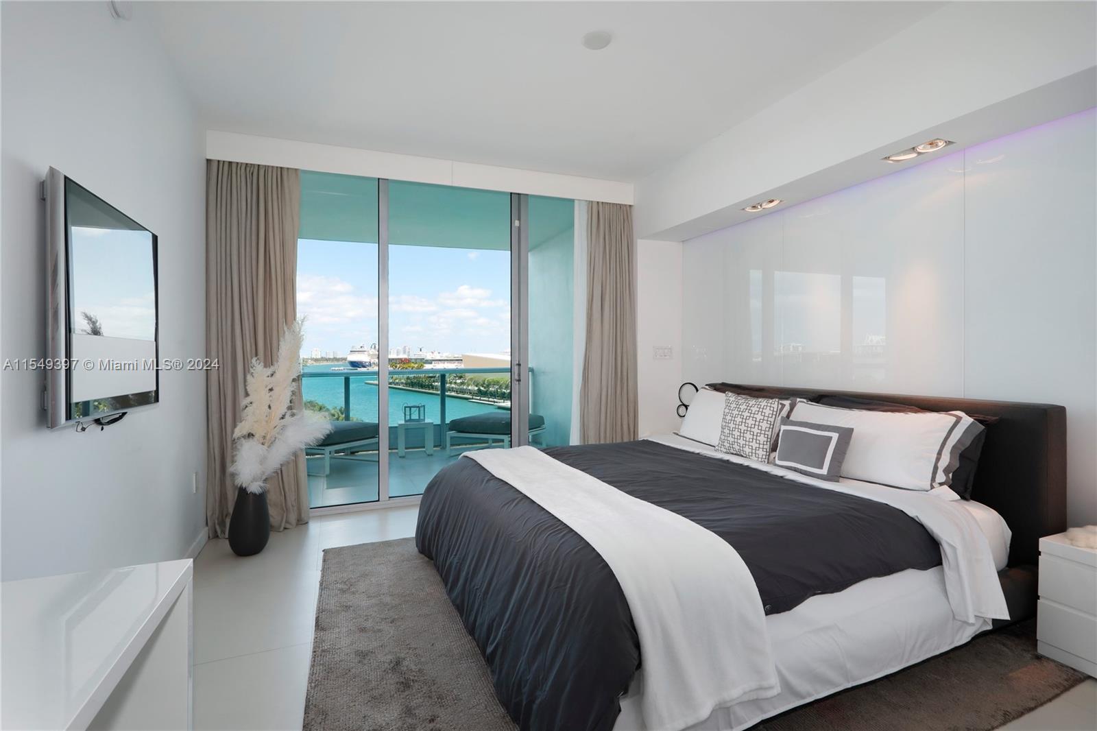 900 Biscayne Boulevard, Unit 705 Miami, FL 33132 - Photo 18 of 30 a bedroom with a balcony a bed and a couch