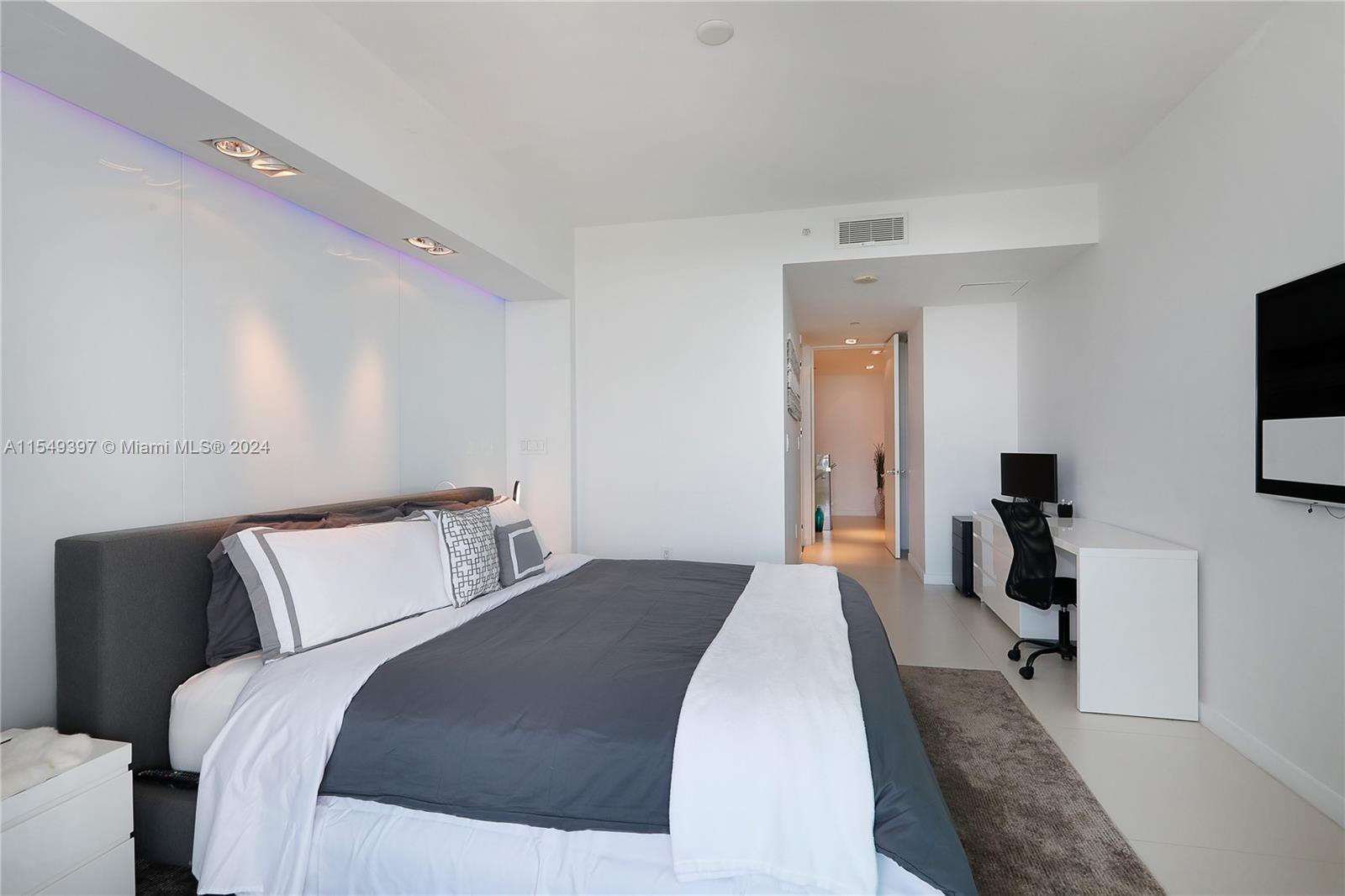 900 Biscayne Boulevard, Unit 705 Miami, FL 33132 - Photo 20 of 30 a bedroom with a bed and a flat tv screen on dresser