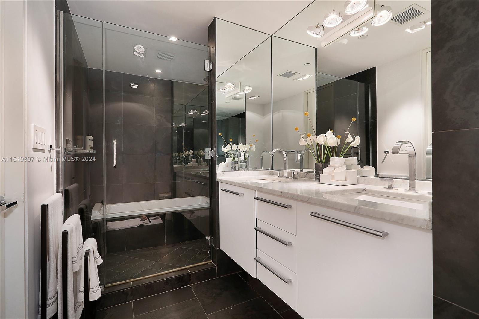 900 Biscayne Boulevard, Unit 705 Miami, FL 33132 - Photo 21 of 30 a bathroom with a double vanity sink a mirror and a shower