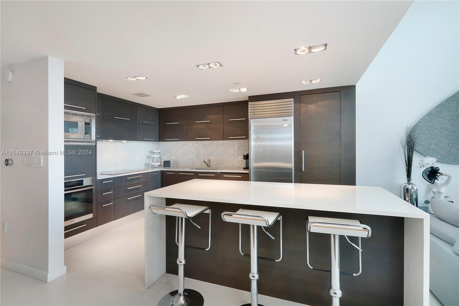 900 Biscayne Boulevard, Unit 705 Miami, FL 33132 - Photo 10 of 30 a kitchen with stainless steel appliances granite countertop a stove a refrigerator and a sink