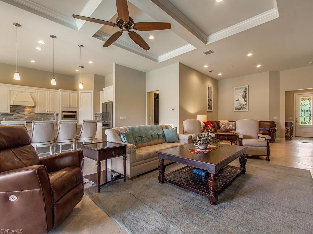 7263 Clamshell Lane Naples, FL 34114 - Photo 2 of 11 a living room with furniture kitchen view and a chandelier