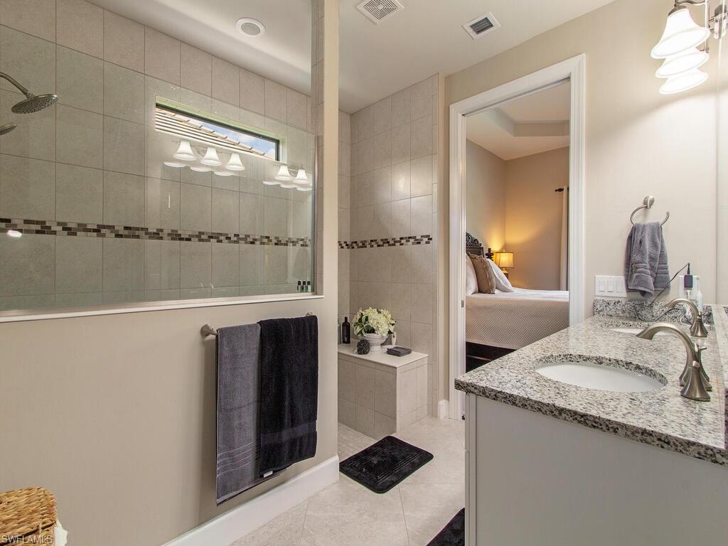 7263 Clamshell Lane Naples, FL 34114 - Photo 7 of 11 a bathroom with a granite countertop sink and a mirror