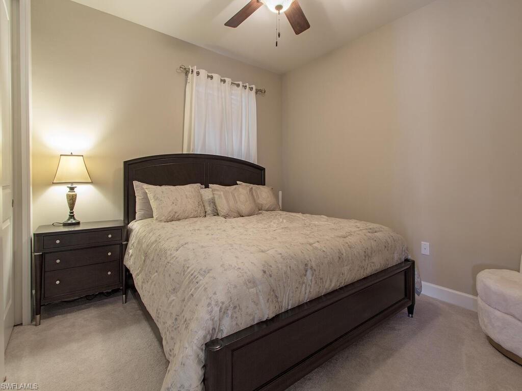 7263 Clamshell Lane Naples, FL 34114 - Photo 8 of 11 a bedroom with a bed and a lamp