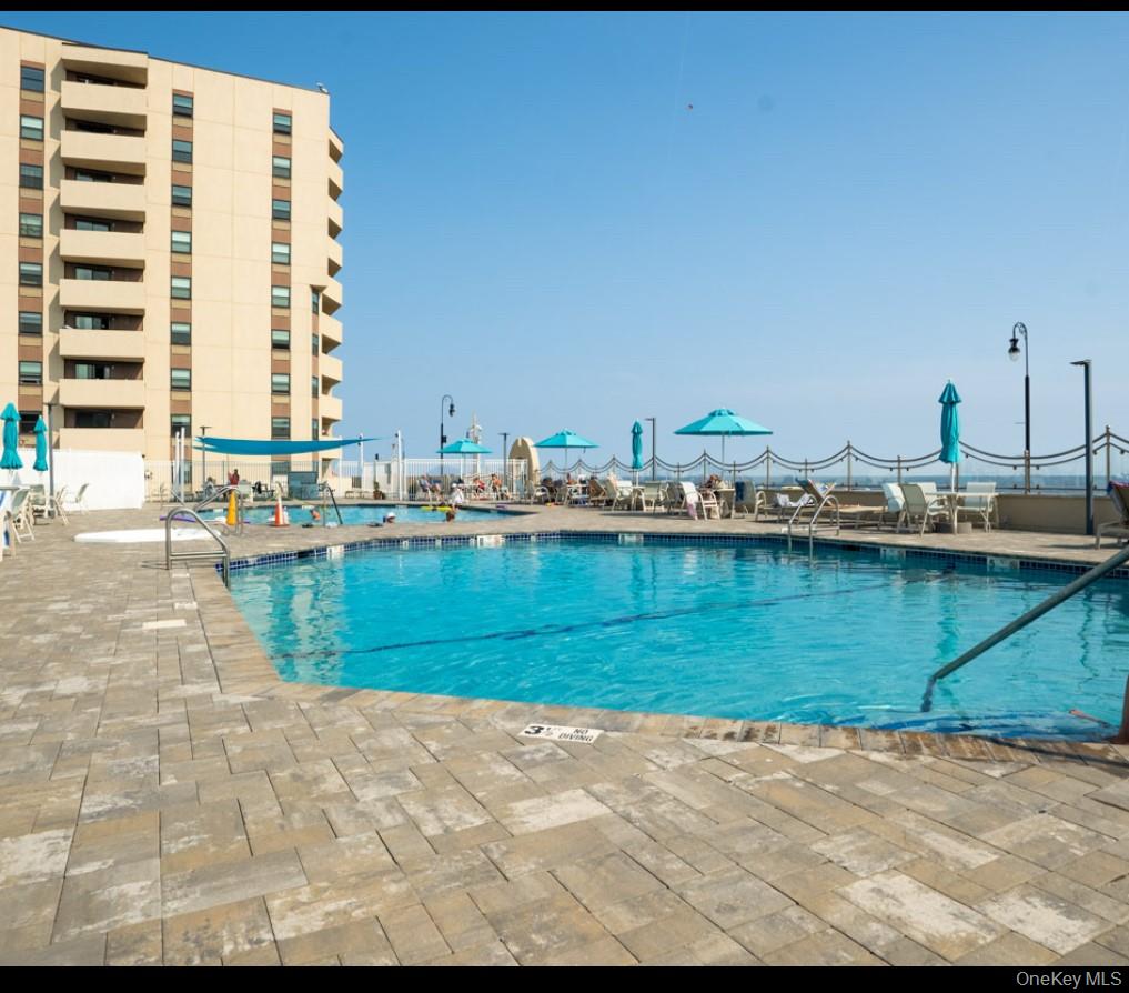 360 Shore Road, Unit 4B Long Beach, NY 11561 - Photo 8 of 28 Community pool featuring a patio