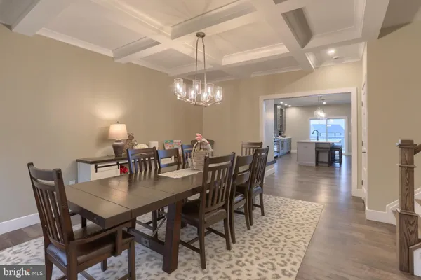 a dining room with wooden floor a chandelier a wooden table and chairs