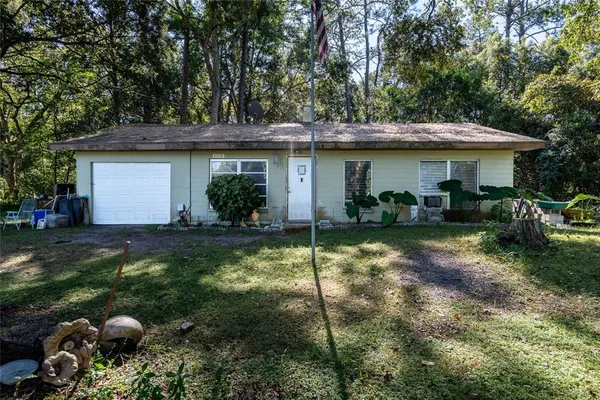 a view of a house with backyard and sitting area