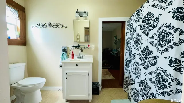 a bathroom with a toilet and a shower curtain