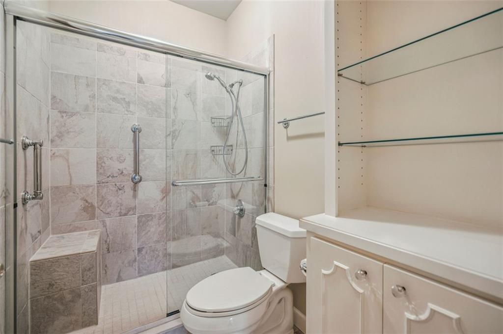 2499 Peachtree Street Northeast, Unit 406 Atlanta, GA 30305 - Photo 25 of 28 a white toilet sitting next to a bath tub and a shower
