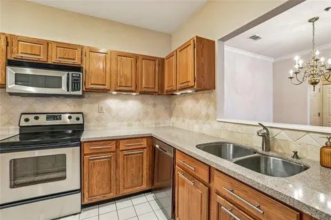 a kitchen with granite countertop a sink and stove top oven