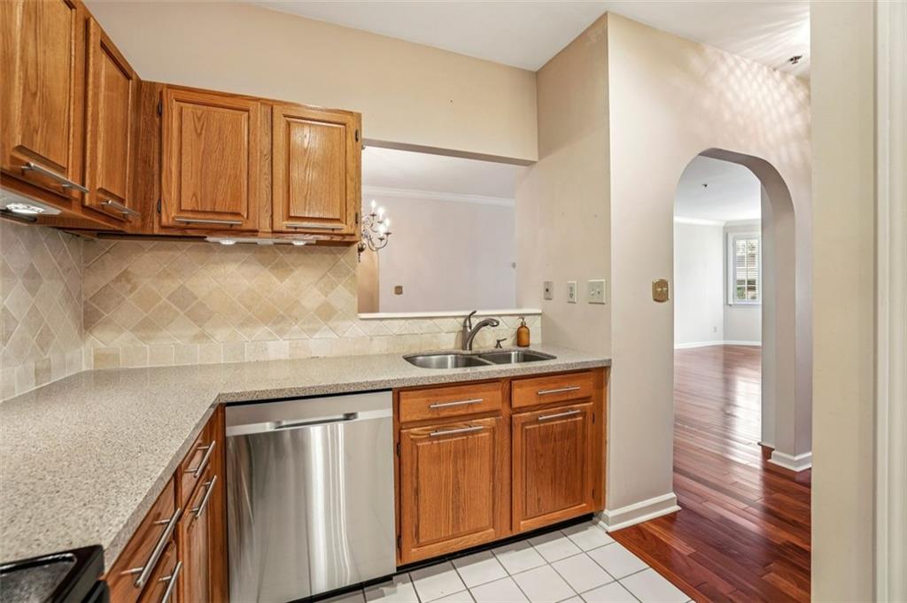 2499 Peachtree Street Northeast, Unit 406 Atlanta, GA 30305 - Photo 7 of 28 a kitchen with stainless steel appliances granite countertop a sink and cabinets with wooden floor